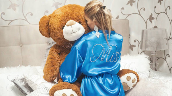 woman wearing custom robe hudding a big teddy bear