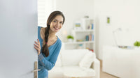 Cheerful woman inviting people to enter in home