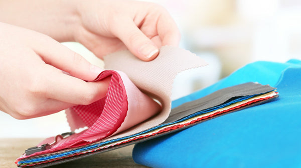 female hands on colorful fabric samples