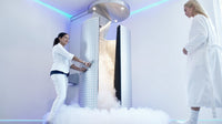 nurse opening the door of cryosauna, with woman in bathrobe at the clinic