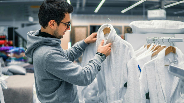 male customer inspecting bathrobe before buying it