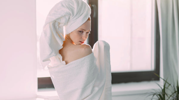 Rear shot of slim young female model wrapped in towel with turban on head