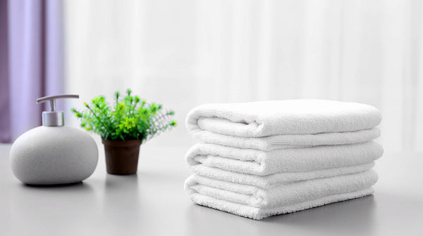 Stack of white clean towels on table in bathroom