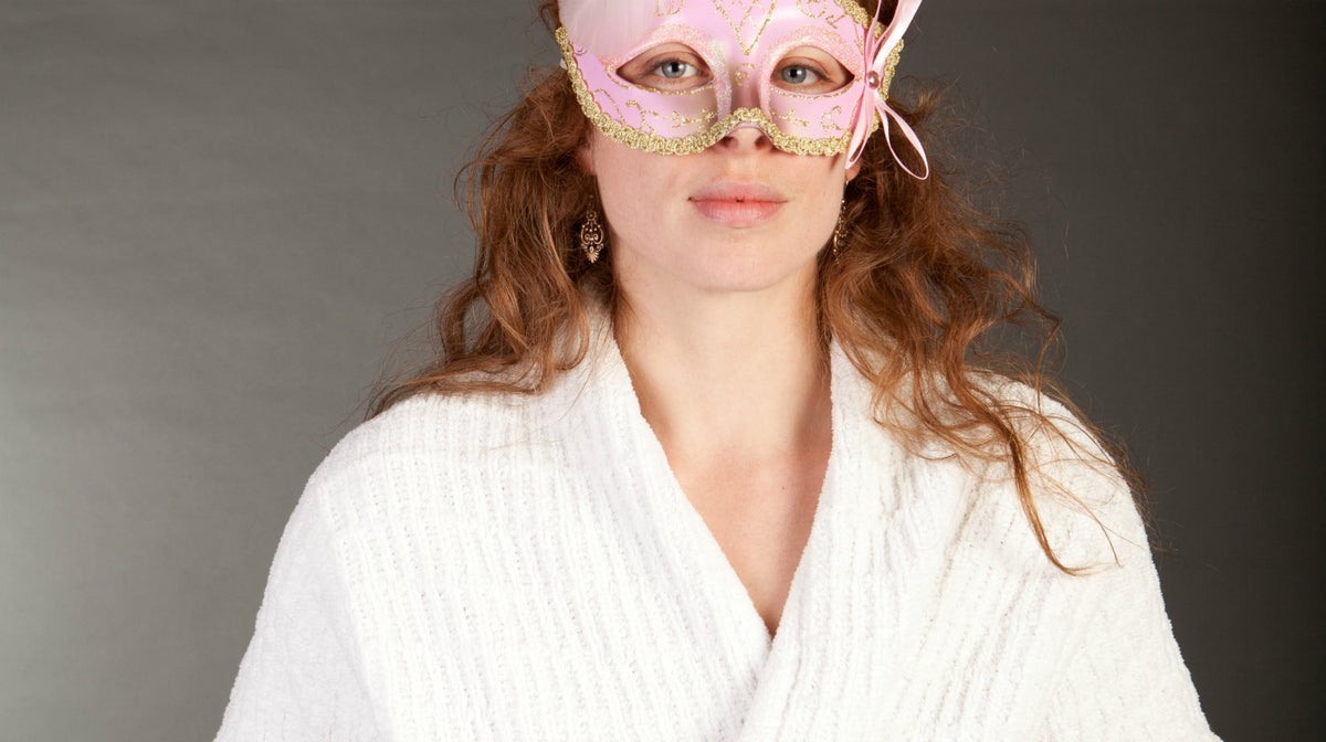 woman wearing pink carnival mask and white bathrobe