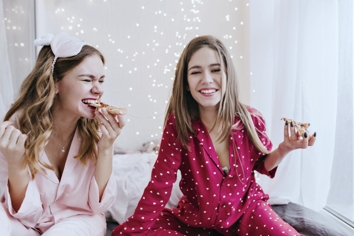 two girls eating pizza | How To Plan A Pajama Party That You And Your Friends Will Enjoy | pajamas