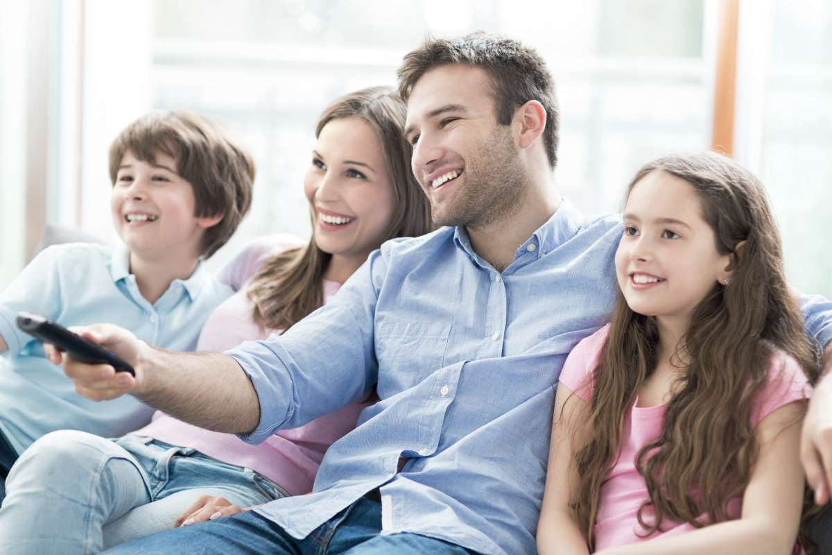 family watching TV smiling | Ways to Make Family Movie Night Even More Fun | movie night | ladies night out movie