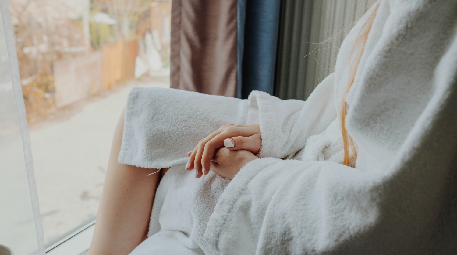 woman wearing bathrobe beside the window | How To Take Care Of Your Cotton, Silk, And Linen Robe/Bathrobes | bathrobes | bathrobes for women | Featured