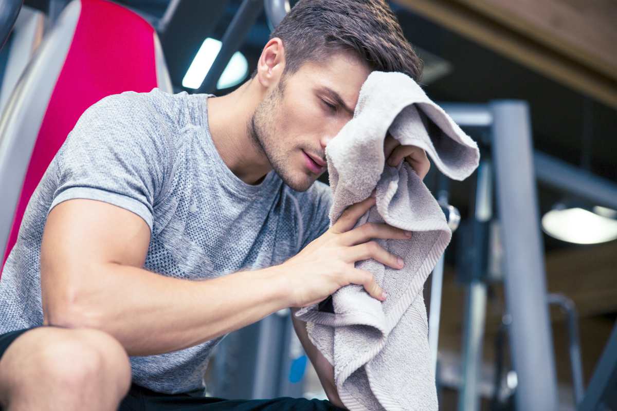 man wiping his face with towel | How To Choose The Best Workout Towel For Your Gym Facility | gym towel | gym shower towel