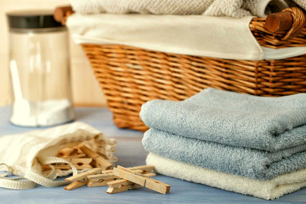 Clothespins in the bag, towels, laundry detergent and a basket in laundry room | Tips Before Washing A Terry Cloth Robe