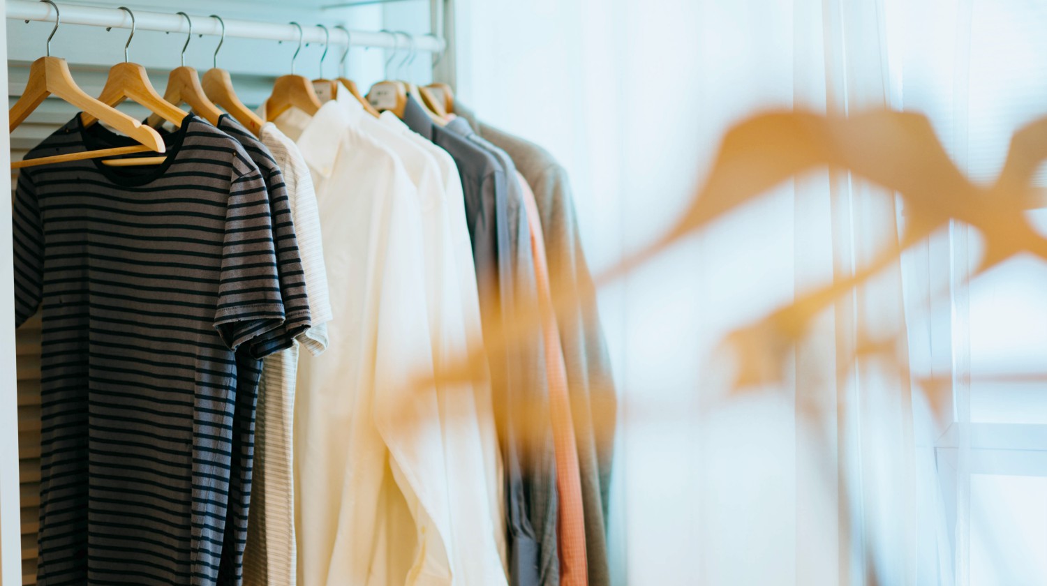 selective focus photography of shirts hanging on rack | How To Start A Minimalist Wardrobe | minimalist wardrobe | minimalist wardrobe men | Featured