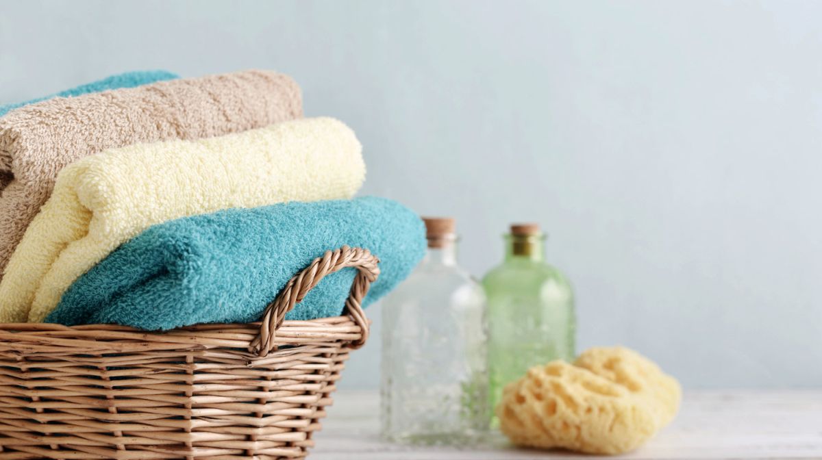 towel in a basket | Types Of Fabric: How To Wash And Care For Your Towels, Robes, and Bathroom Textiles