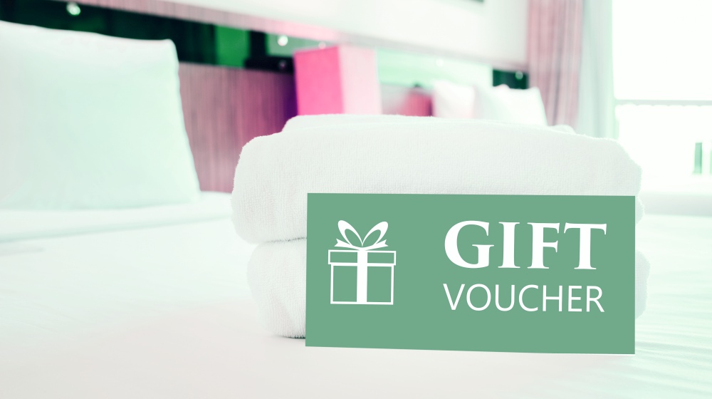 gift voucher card placed on bed | Ways To Improve Hotel Guest Experience | hotel guest | customer satisfaction