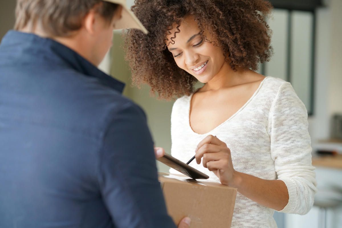 Mixed race woman receiving package from delivery man | Tips On Choosing The Best Bride And Bridesmaid Robes | bridesmaid robes | personalized bridesmaid robes