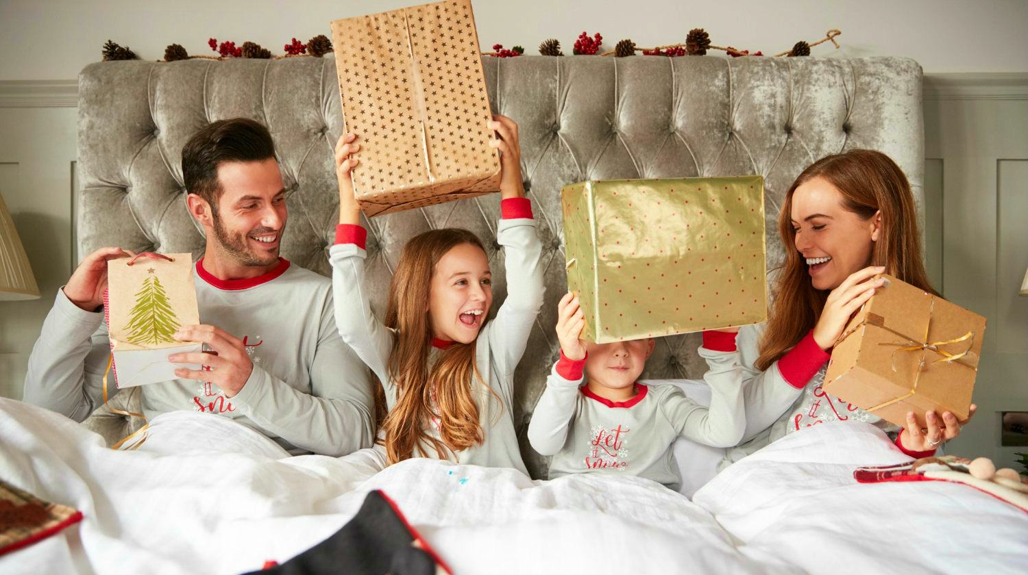 Featured | Excited Family In Bed At Home Opening Gifts On Christmas Day | Occasions For Matching Family Pajamas And Why They're The Perfect Gift
