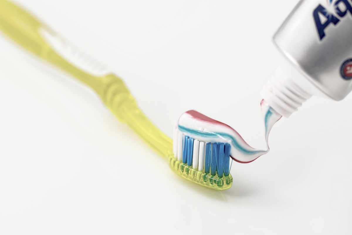 toothpaste and toothbrush on white background | Top Things Every Motel Room Should Have | motel room | items for motel