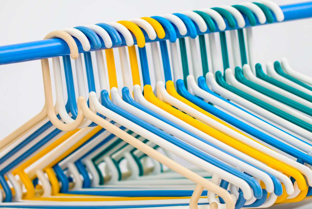 different colored hangers on rack | Top Things Every Motel Room Should Have | motel room | items for motel rooms
