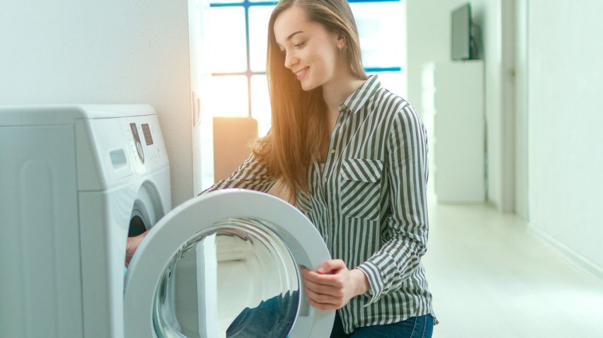 woman doing laundry | Types Of Fabric: How To Wash And Care For Your Towels, Robes, and Bathroom Textiles