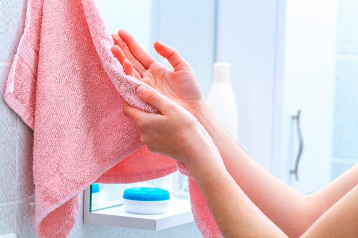 person wiping hands using towel | How To Choose The Right Wholesale Towels For Your Business | wholesale towels | wholesale hand towels