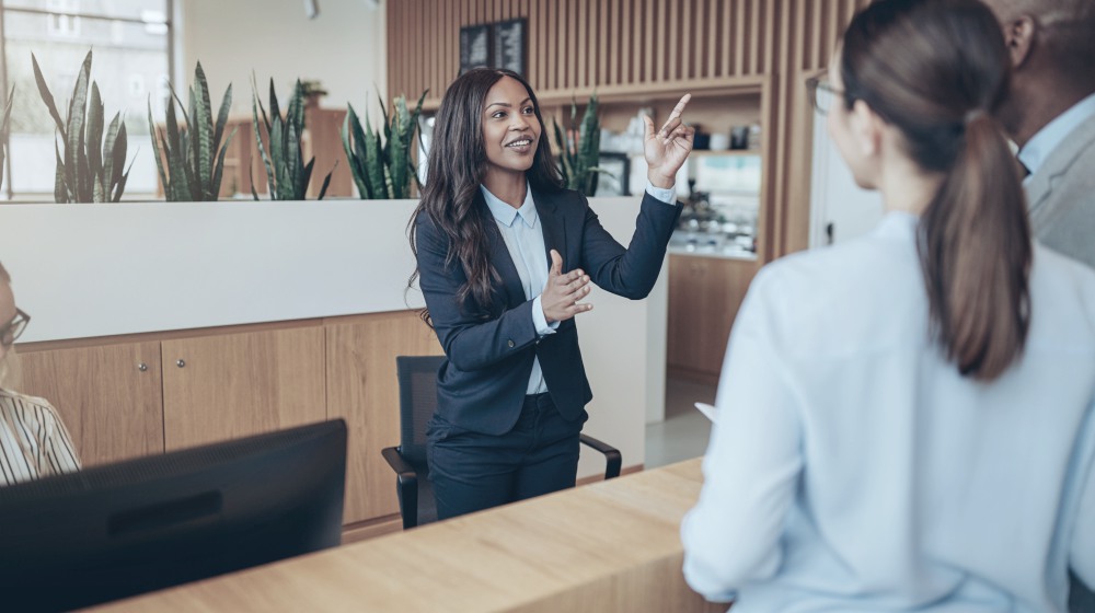 smiling young african american concierge giving directions | Ways To Improve Hotel Guest Experience | hotel guest | hotel guest experience