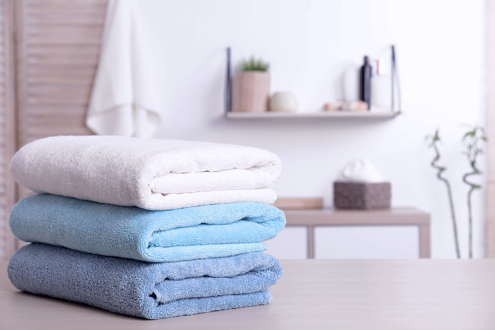 Stack of fresh towels on table in bathroom | How To Choose The Best Luxury Bath Towels | luxury towels | best luxury towels