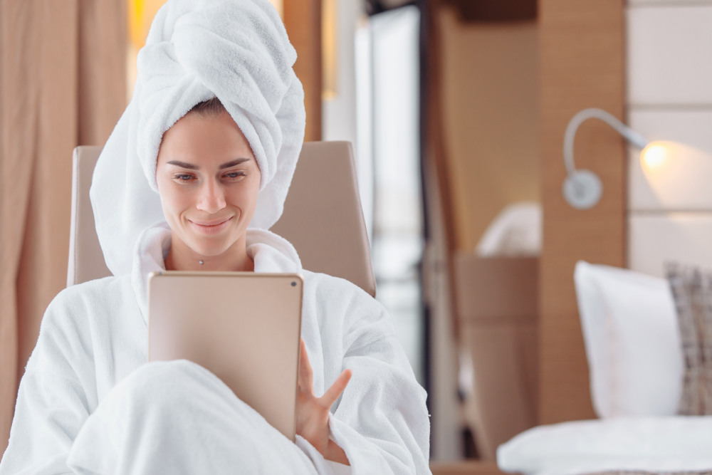 Cheerful young beautiful woman is resting after shower | Why A White Towel Should Be A Bathroom Staple | white beach towel