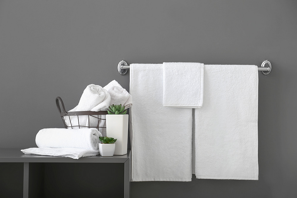 White bath towels near grey wall | Airbnb Towels: Everything You Need To Know | airbnb sheets and towels