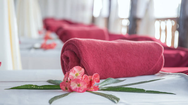 rolled pink bath towels on bench